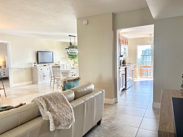 tiled living room with ceiling fan and a textured ceiling