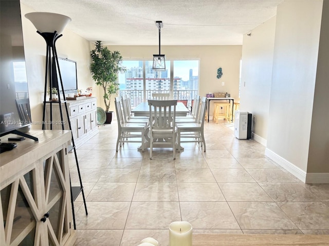 dining area with light tile patterned floors and a textured ceiling