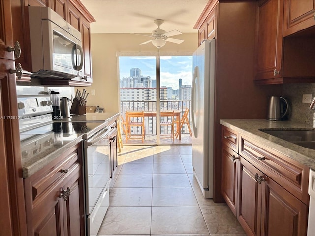 kitchen with sink, white appliances, ceiling fan, tasteful backsplash, and light tile patterned flooring