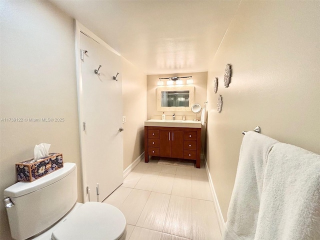 bathroom featuring tile patterned flooring, vanity, and toilet