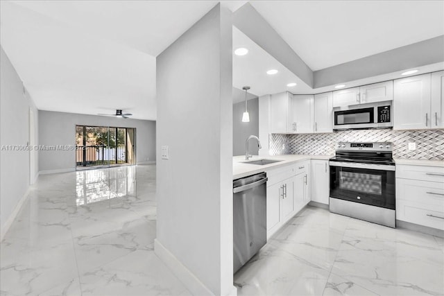 kitchen featuring sink, hanging light fixtures, white cabinets, stainless steel appliances, and backsplash