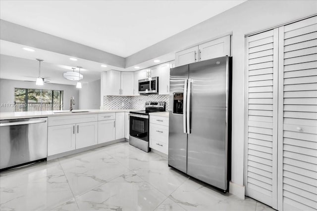 kitchen featuring tasteful backsplash, sink, white cabinets, and appliances with stainless steel finishes