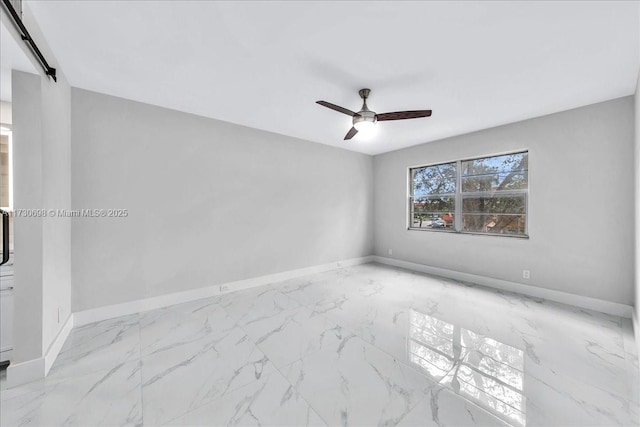 empty room with ceiling fan and a barn door