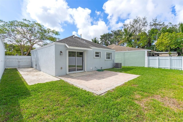 back of property featuring a yard, central AC unit, and a patio area