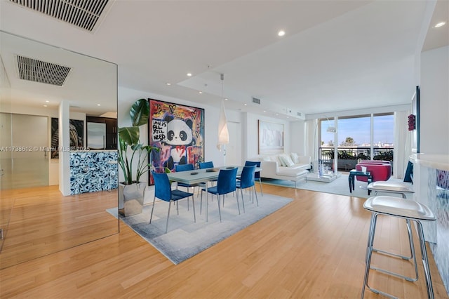 dining area featuring expansive windows and light wood-type flooring