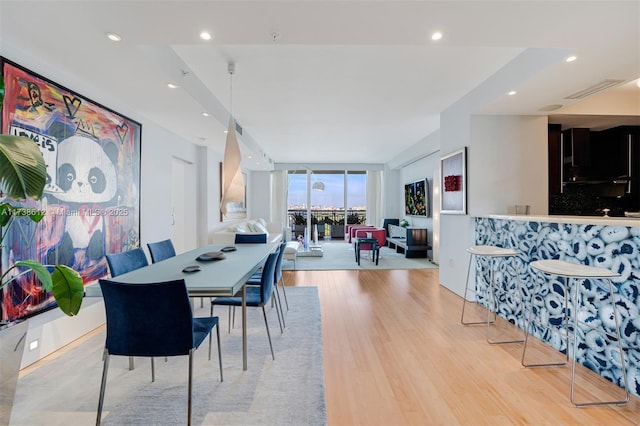 dining room featuring a wall of windows and light hardwood / wood-style floors