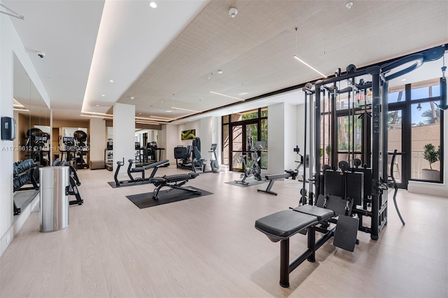 workout area featuring light hardwood / wood-style flooring and a wall of windows