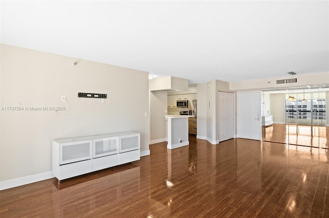 unfurnished living room featuring dark wood-type flooring