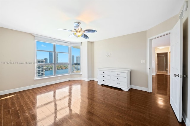 unfurnished room featuring dark wood-type flooring and ceiling fan