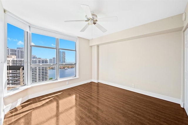 spare room featuring hardwood / wood-style floors, ceiling fan, and a water view