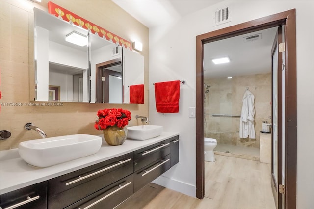 101 Ocean Lane Dr Unit 1017, Key Biscayne, FL 33149 - bathroom with wood finished floors, double vanity, a shower stall, toilet, and baseboards