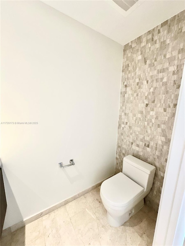 bathroom with tile patterned flooring, toilet, and baseboards