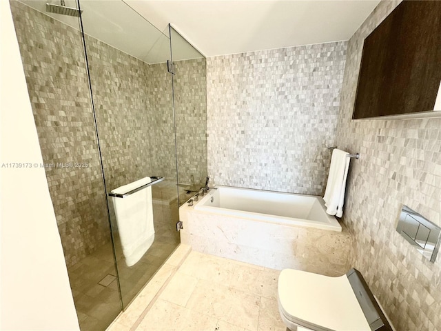 full bath with a shower stall, toilet, tile walls, and a garden tub