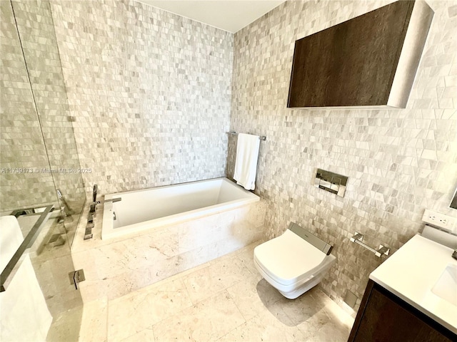 bathroom featuring tiled tub, toilet, tile walls, and vanity