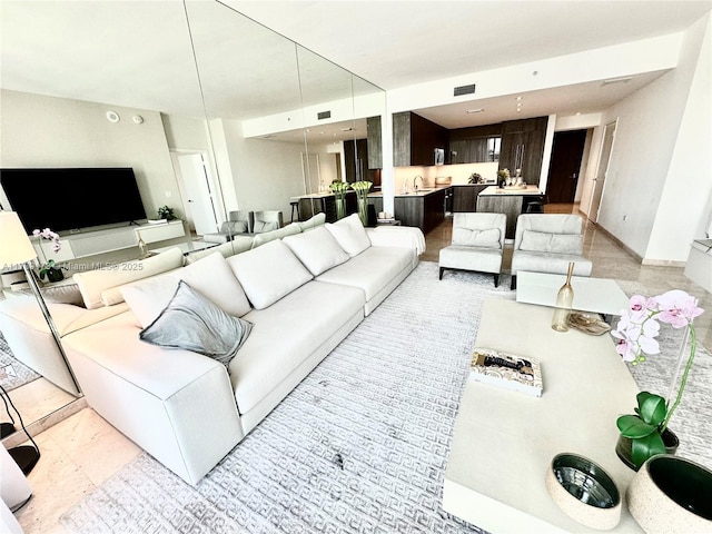 living area featuring baseboards and visible vents