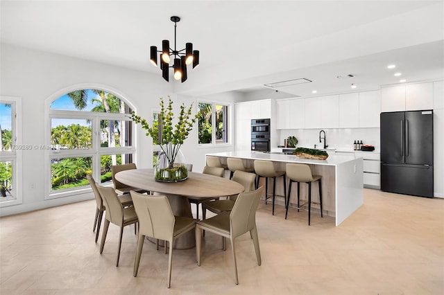 dining space featuring sink and a notable chandelier