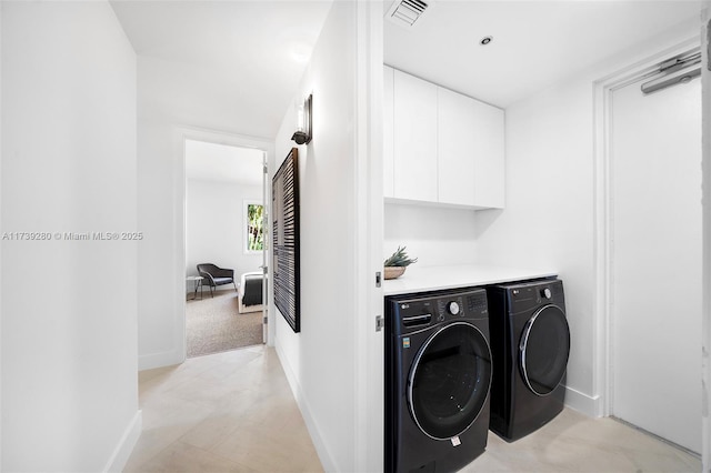 clothes washing area with independent washer and dryer and cabinets