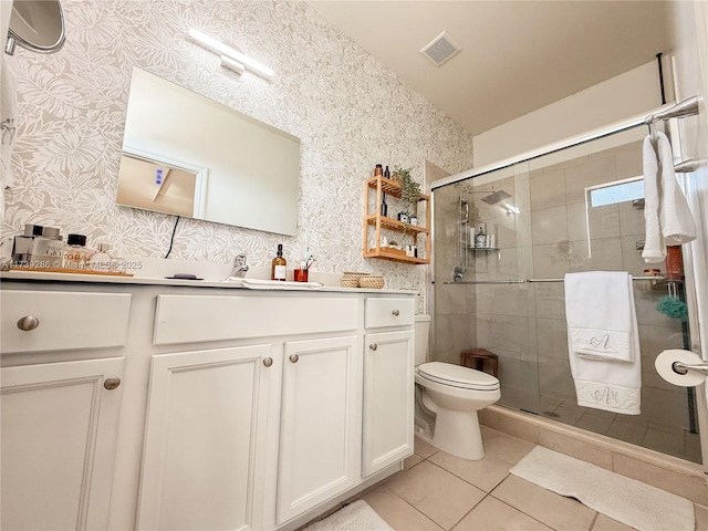 bathroom featuring vanity, tile patterned flooring, a shower with door, and toilet