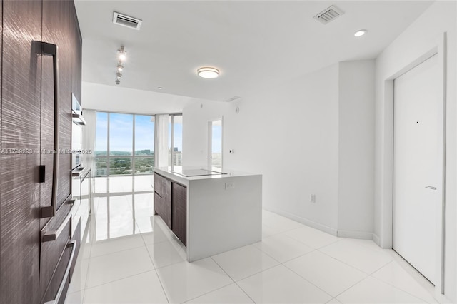 kitchen with a center island, light tile patterned floors, and black electric cooktop