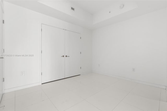 unfurnished bedroom with light tile patterned floors and a closet