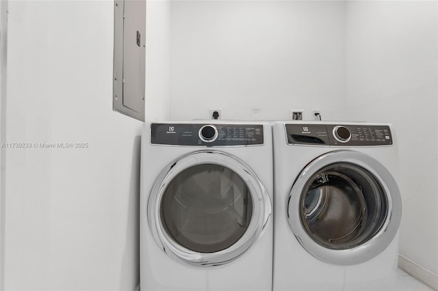 laundry area with electric panel and washer and dryer