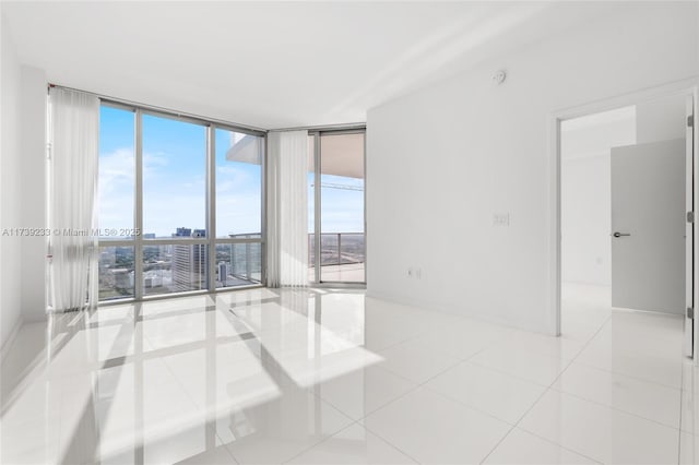 empty room featuring light tile patterned flooring and floor to ceiling windows