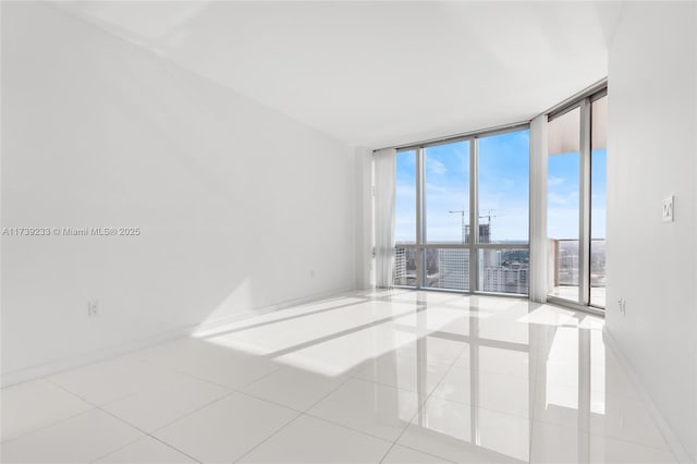 unfurnished room featuring expansive windows and light tile patterned floors