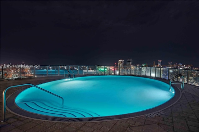 view of pool at twilight