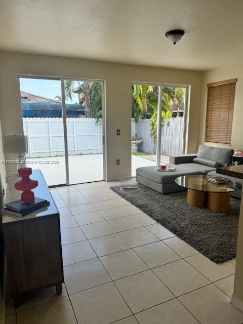 doorway to outside featuring a textured ceiling and light tile patterned flooring