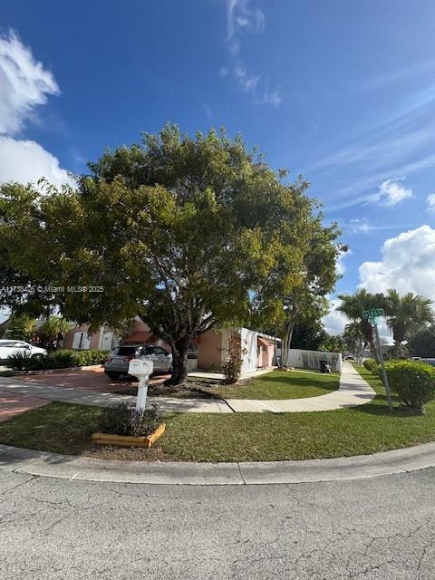 view of property hidden behind natural elements with a front lawn