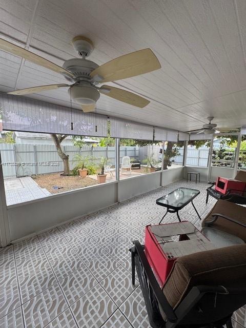 sunroom / solarium featuring ceiling fan