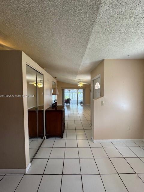 corridor with light tile patterned floors and a textured ceiling