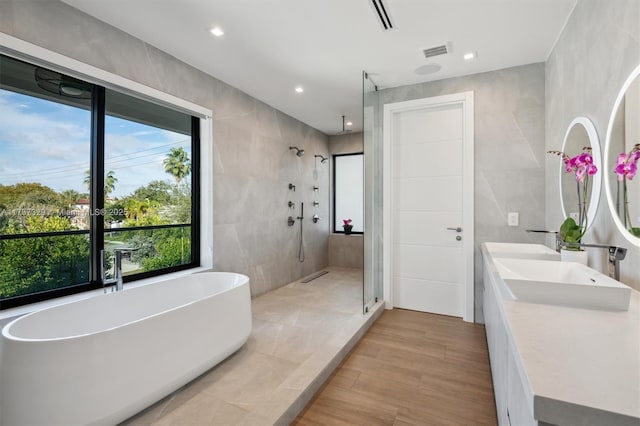 bathroom with vanity, plus walk in shower, and tile walls