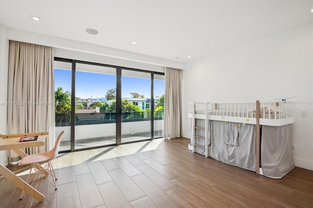 bedroom featuring wood-type flooring and access to outside