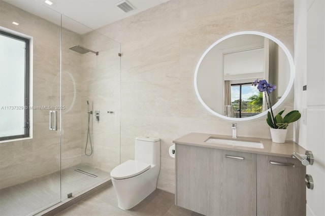 bathroom with vanity, toilet, tile walls, and a shower with shower door