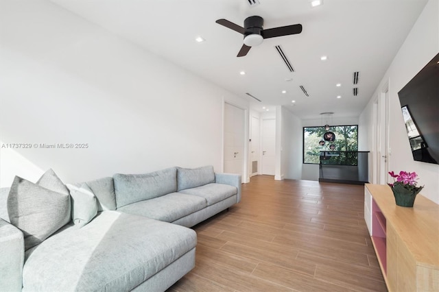 living room with ceiling fan and light wood-type flooring