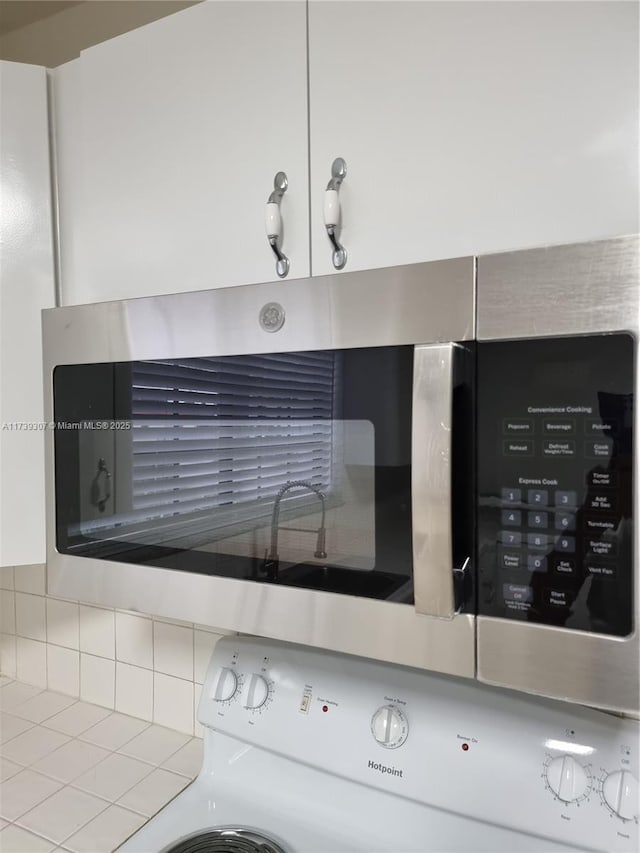 interior details with white cabinetry and electric range