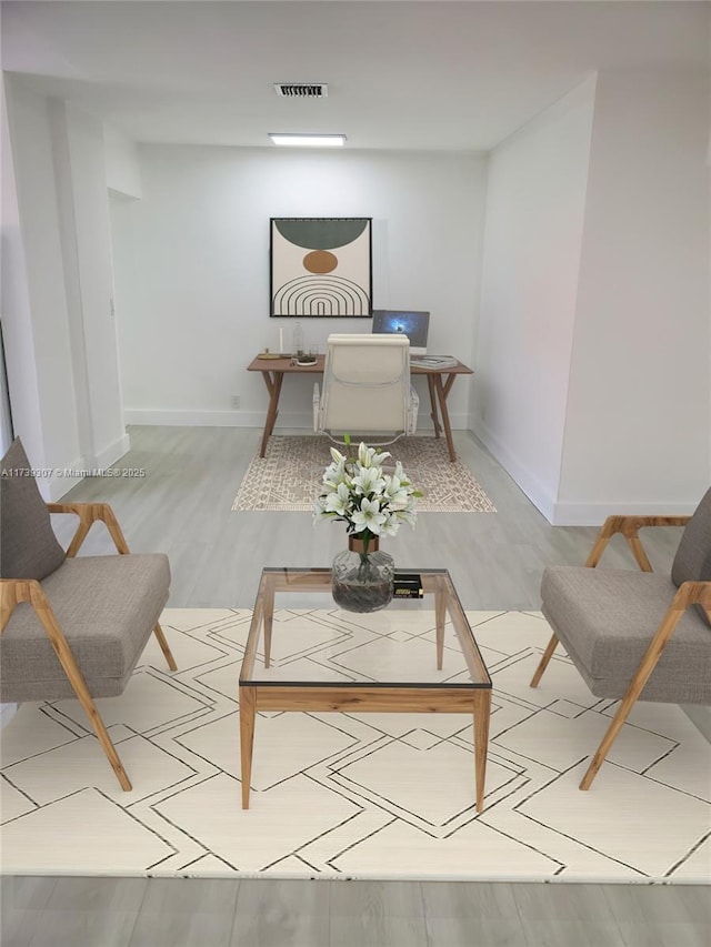 interior space featuring baseboards, wood finished floors, and visible vents