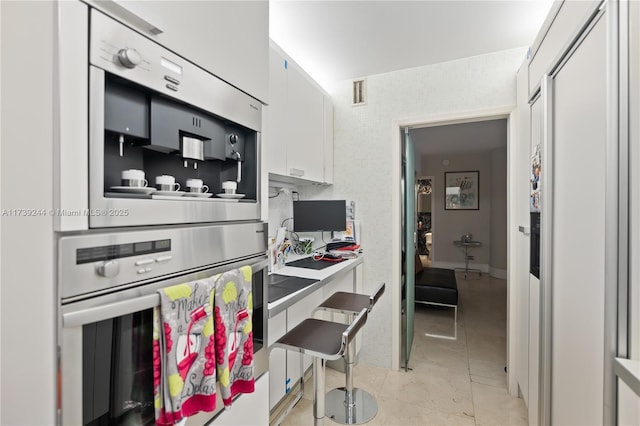 kitchen with stainless steel double oven and white cabinets