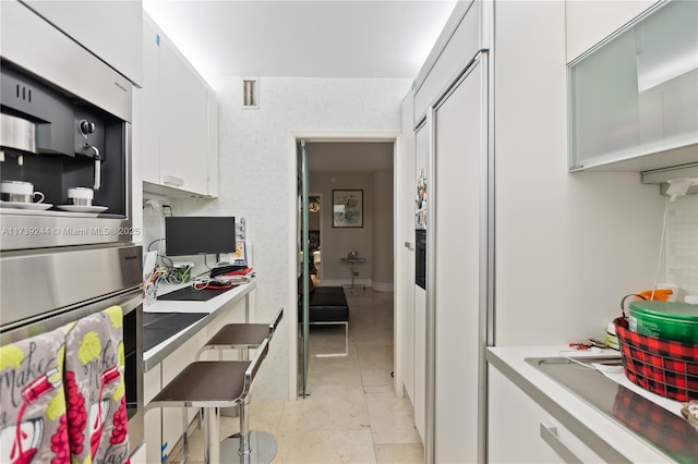 kitchen featuring white cabinetry and light tile patterned flooring