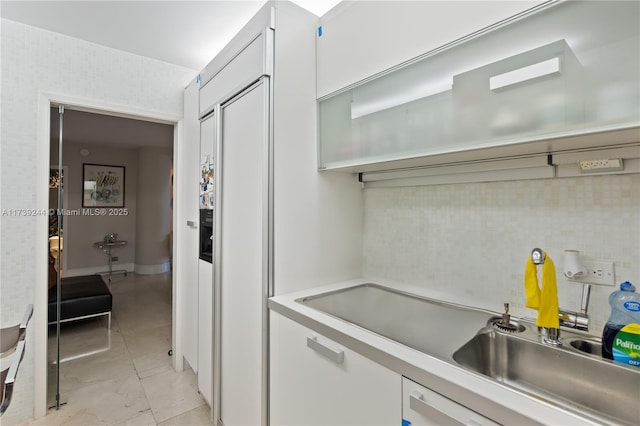 kitchen featuring backsplash and white cabinets