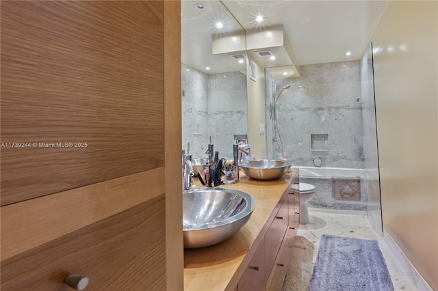 bathroom featuring vanity, toilet, and tile walls