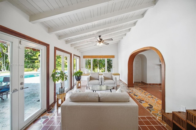 sunroom / solarium featuring arched walkways, a ceiling fan, lofted ceiling with beams, wooden ceiling, and french doors