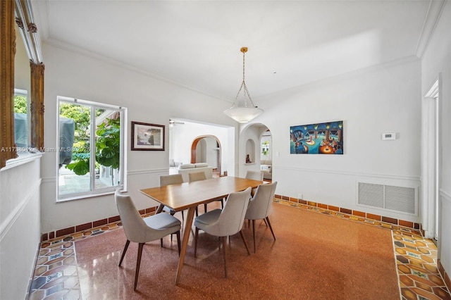 dining area featuring arched walkways, visible vents, crown molding, and baseboards