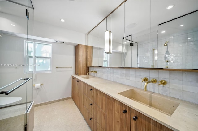 bathroom with baseboards, a sink, and decorative backsplash