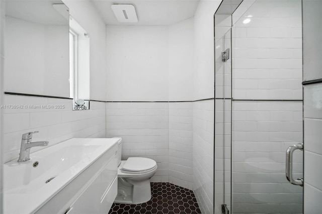 bathroom with toilet, a stall shower, vanity, and tile walls