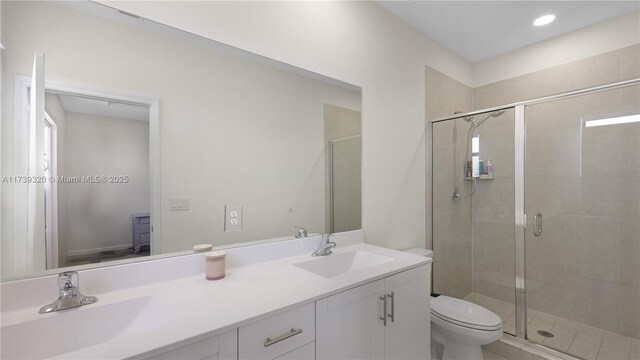 bathroom with an enclosed shower, vanity, and toilet