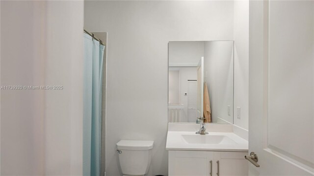 bathroom with vanity, curtained shower, and toilet