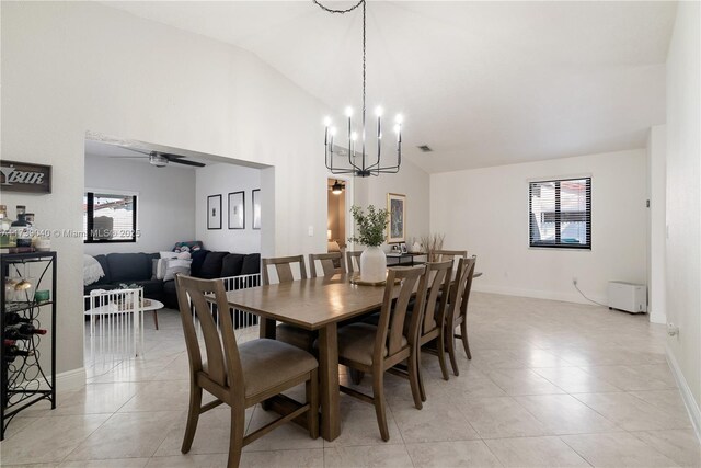 dining area featuring light tile patterned floors, ceiling fan with notable chandelier, and high vaulted ceiling