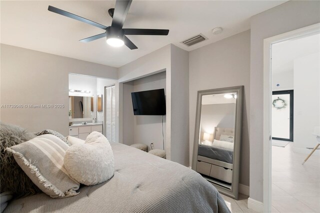 bedroom featuring ensuite bathroom, light tile patterned floors, and ceiling fan